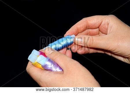 Female Hands Hold Skeins Of Thread. Silk Threads For Embroidery. Yellow, Lilac And Pink Skeins In Th