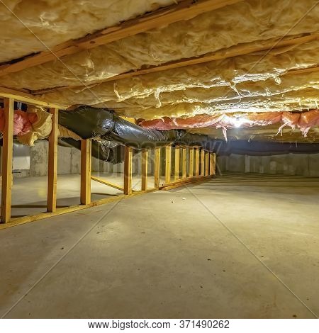 Square Frame Basement Or Crawl Space With Upper Floor Insulation And Wooden Support Beams