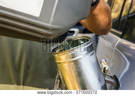 Male Worker Adds An Additive To Diesel Fuel. Increase Combustion Efficiency. A Male Hand Pours Fuel 