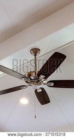 Vertical Decorative Wood Beam With Standard Ceiling Fan And Lights Inside A House