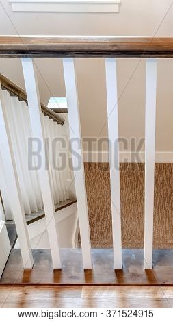 Vertical Frame U Shaped Stairway Of Home With Brwon Handrail Supported By White Balusters