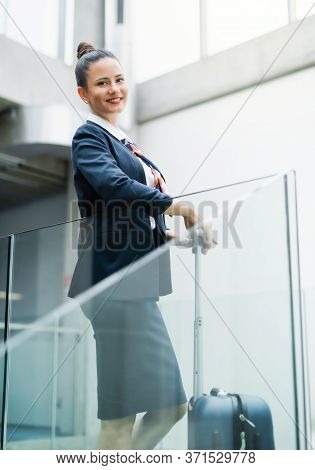Portrait Of Attractive Flight Attendant Standing On Airport, Looking At Camera.