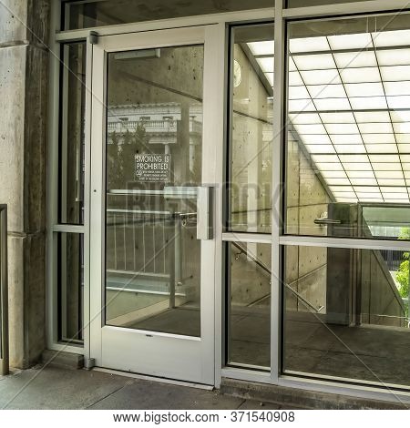 Square Crop Glass Door And Wall With View Of Slanted Frosted Roof Over Stairway Of Building
