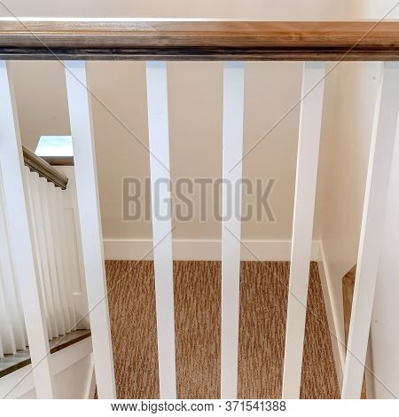 Square Frame U Shaped Stairway Of Home With Brwon Handrail Supported By White Balusters