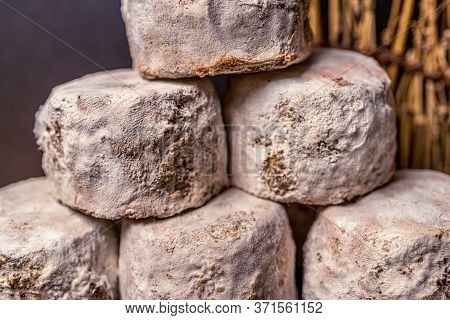 French Cheese Crottin De Chavignol In The Dark Background. High Quality Photo