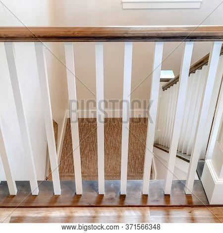 Square U Shaped Stairway Of Home With Brwon Handrail Supported By White Balusters