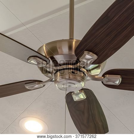 Square Electrical Fan With Built In Lights Installed On Decorative Wooden Ceiling Beam