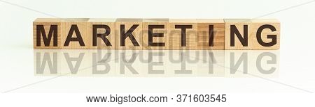 Wooden Blocks With The Text: Marketing. The Text Is Written In Black Letters And Is Reflected In The