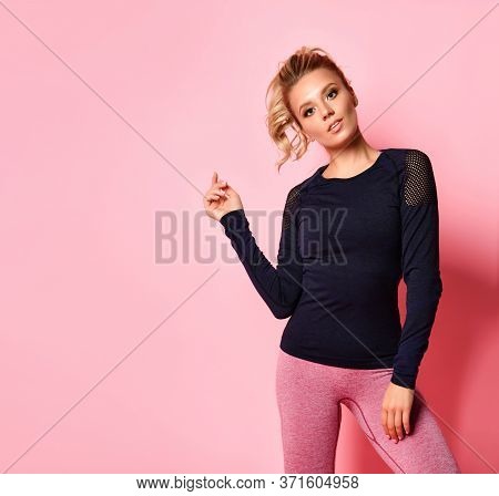 Cheerful Slim Young Girl In Stylish Black Long Sleeve T-shirt And Rose Leggings Looking Forward Bend