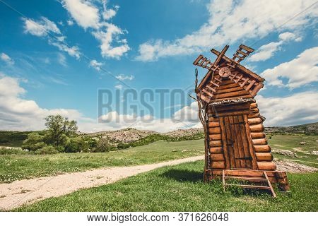 Landscape Scenery Of Wooden Windmill On A Hill, Touristic Sightsing.