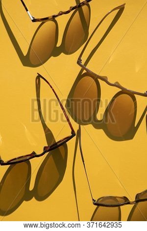 Sunglasses With Long Shadow On A Brignt Summer Yellow Background