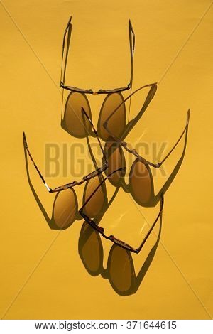 Sunglasses With Long Shadow On A Brignt Summer Yellow Background