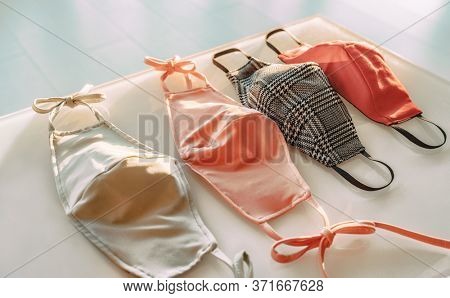 Many fabric face masks for sale at fashion designer store selling clothing and cloth mask made for COVID-19 prevention on shop shelf. Wearing a polyester or cotton mouth covering against coronavirus.