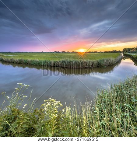 Wide Angle Landscape Over River Bend At Sunset In Flat Agricultural Landscape In Groningen The Nethe