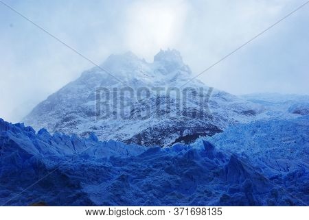 Iceberg With Mountain Behind In Lago Argentino Patagonia