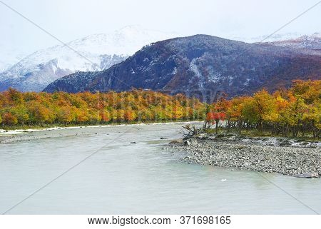 River With Autumn Trees And Mountains Snow Red Tree In Patagonia Argentina