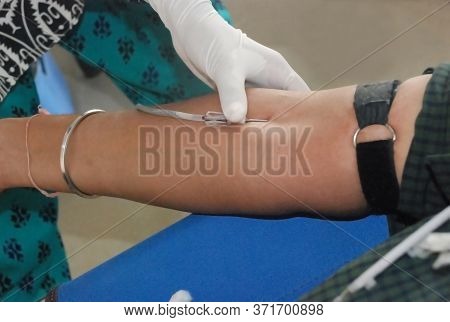 Blood Donation. Female Doctor Tacking Blood On Man Hand.