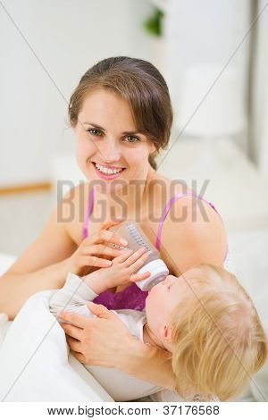 Jovem feliz mãe bebê alimentação