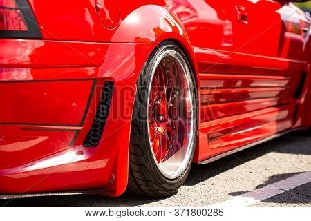 Red Sports Tuned Car Rear View Of The Wheel, Close-up . Fashion Car Day On The Road
