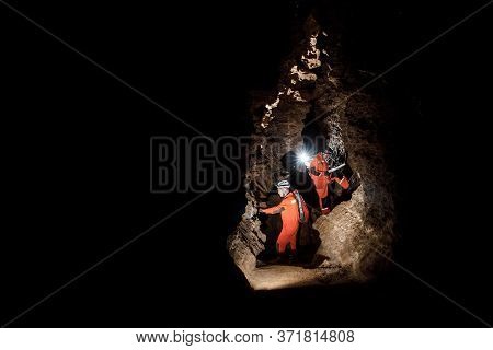 Two Men, Strong Physique, Explore The Cave. Men Dressed In Special Clothes To Pass Through The Cave 