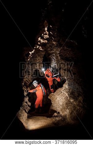Two Men, Strong Physique, Explore The Cave. Men Dressed In Special Clothes To Pass Through The Cave 