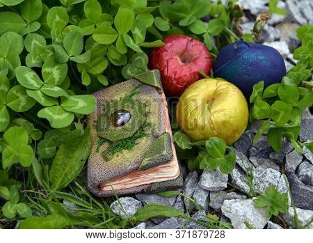 Fairy Tale Book And Three Magic Apples Outdoors In The Garden. Esoteric, Gothic And Occult Backgroun