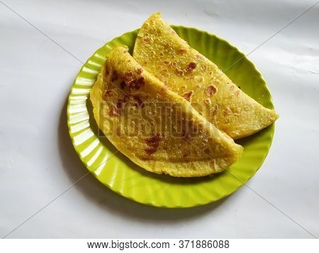 Closeup Of Yellow Color Traditional Dal Obbattu Or Holige In A Plate Isolated On White Background