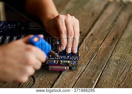 Engineer Or Technician Repair Electronic Circuit Board With Soldering Iron.