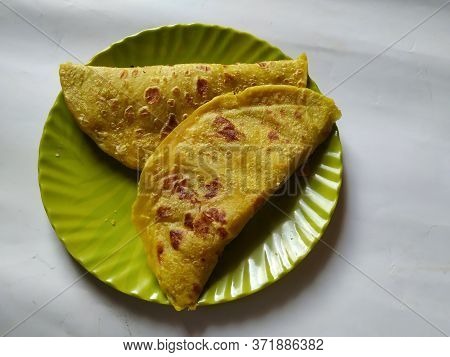 Closeup Of Yellow Color Traditional Dal Obbattu Or Holige In A Plate Isolated On White Background