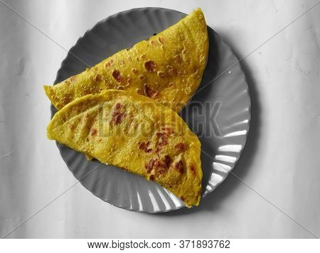 Highlighted Traditional Dal Obbattu Or Holige In A Plate Isolated On White Background