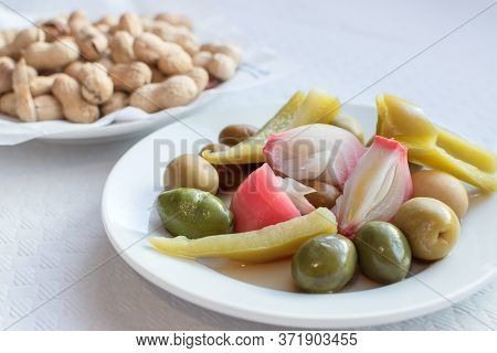 Olives Pepper And Peanuts On A Plate