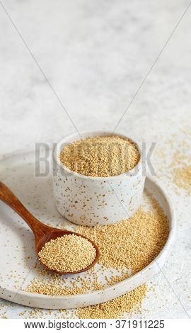 Bowl Of Raw Amaranth Grain With A Spoon Close Up On A White Table