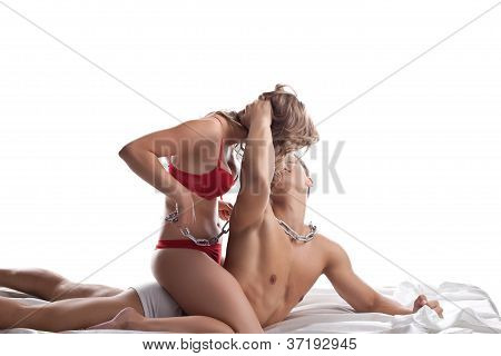 Junge Liebhaber spielen im Bett mit Kette sexuelle Spiele