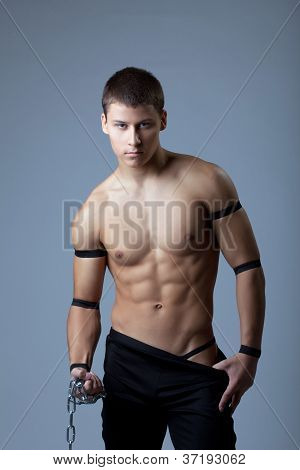 athletic man dance striptease with chain