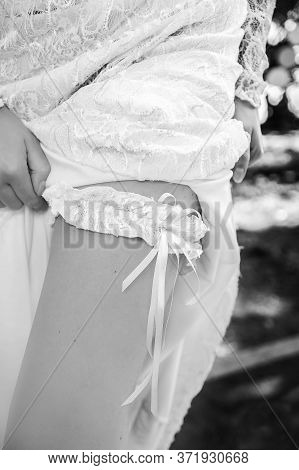The Girl Puts A Lace Garter On Her Bare Leg. Morning Gathering Of The Bride