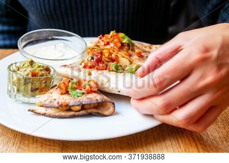 Delicious Mexican quesallidas made with chicken, tomato pieces and served with guacamole sauce.