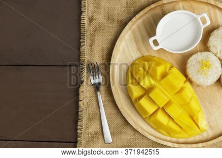 Top View Yellow Half  Mango With Small Fork. Mango Fruit Cubes On The Wooden Table. Tropical Fruit A
