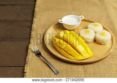 Yellow Half  Mango With Small Fork. Mango Fruit Cubes On The Wooden Table. Tropical Fruit Asia. Fres