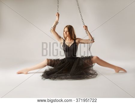 Slender Girl Dancing With A Large Chain In An Incredible Ballerina Pose