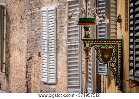 Siena, Italy, April 2018: Street Lamp Of The Goose District In Siena. Tuscany, Italy. Each Colour An