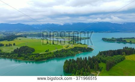Aerial View Over Lake Forggensee At The City Of Fuessen In Bavaria Germany