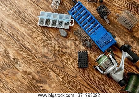 Flat Lay With Fishing Tackle, Fishing Rod And Plastic Box With Fishing Tackle And Hooks, Feeders On 