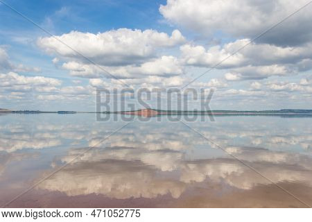 Lake With Clouds In The Sky, Red Hill With Forests On Background