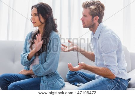 Mujer gesticulando mientras discutiendo con su pareja en la sala de estar