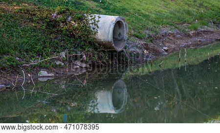 Concrete Circular Run-off Pipe Discharging Water. Sewage Pipe Polluting The River. Sewage Or Domesti