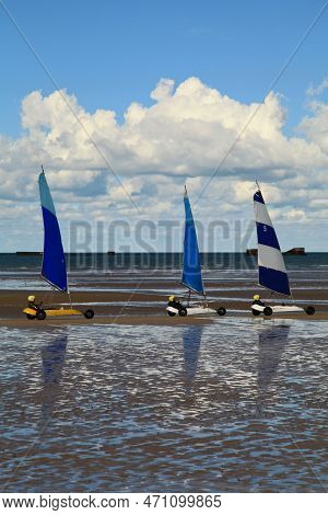 Arromanches, France - October 14 2012: Three People Having A Friendly Sand Yachting Race On Gold Bea