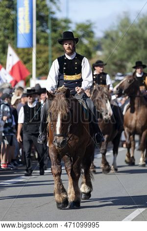 Quimper, France - July 24 2022: Rider In Traditional Breton Dress Riding A Postier Breton During The