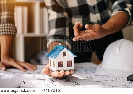 Scale Model House On Table With Architects. Two Architects Making Architectural Model In Office Toge