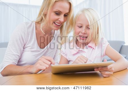 Veselá matka a dcera pomocí digitálních tabletu v obývacím pokoji
