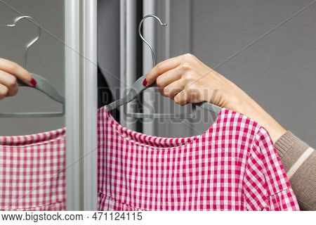 Woman Takes Red Dress Out Of Wardrobe. Woman Trying On A Summer Dress. Woman Chooses A Dress